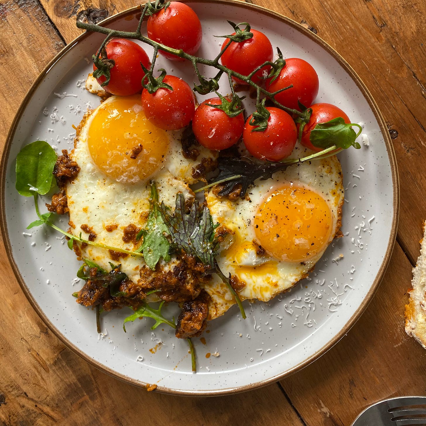 Fried eggs on a plate with vine tomatoes