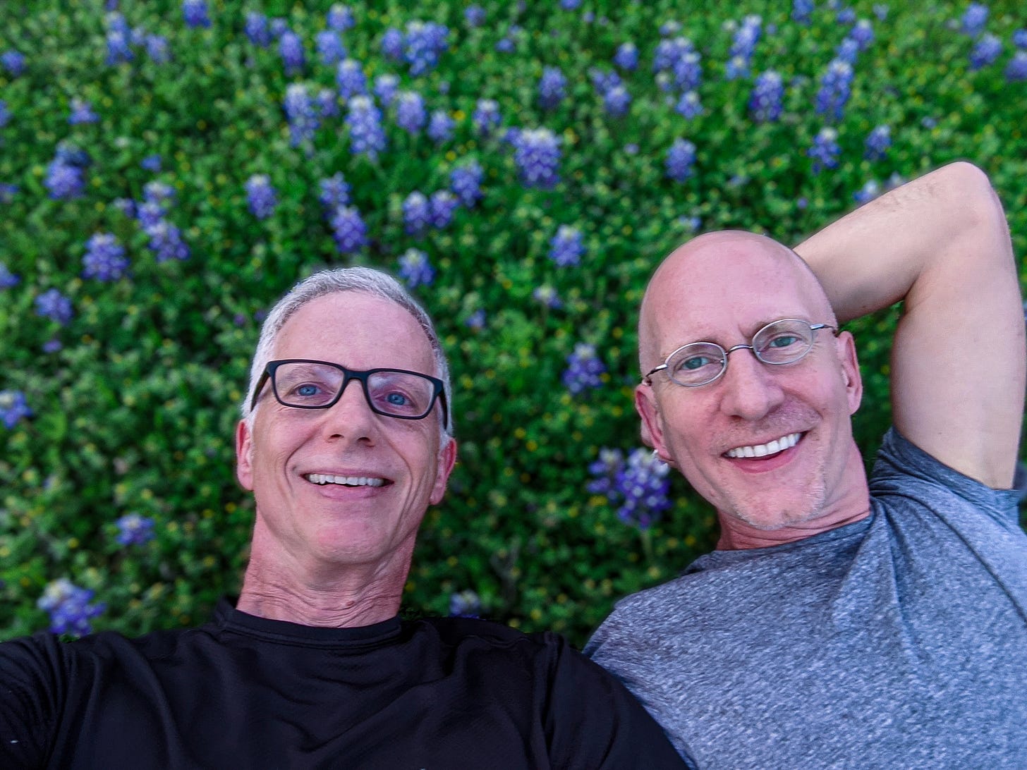 Brent and Michael laying in a field of blue bonnets.