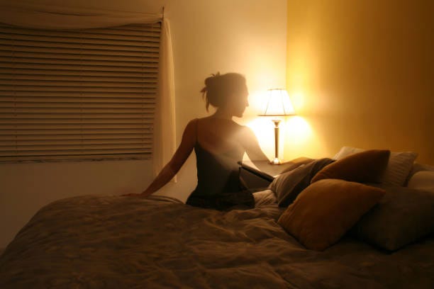 silhouette of woman sitting on bed - love lost stock pictures, royalty-free photos & images