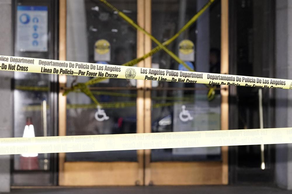 Police tape put up by protesters blocks the entrance of Los Angeles City Hall, Wednesday, Oct. 19, 2022, in Los Angeles. The demonstrators demanded the city council stop its virtual meeting Tuesday until two of its members resign over racist remarks. (AP Photo/Mark J. Terrill)