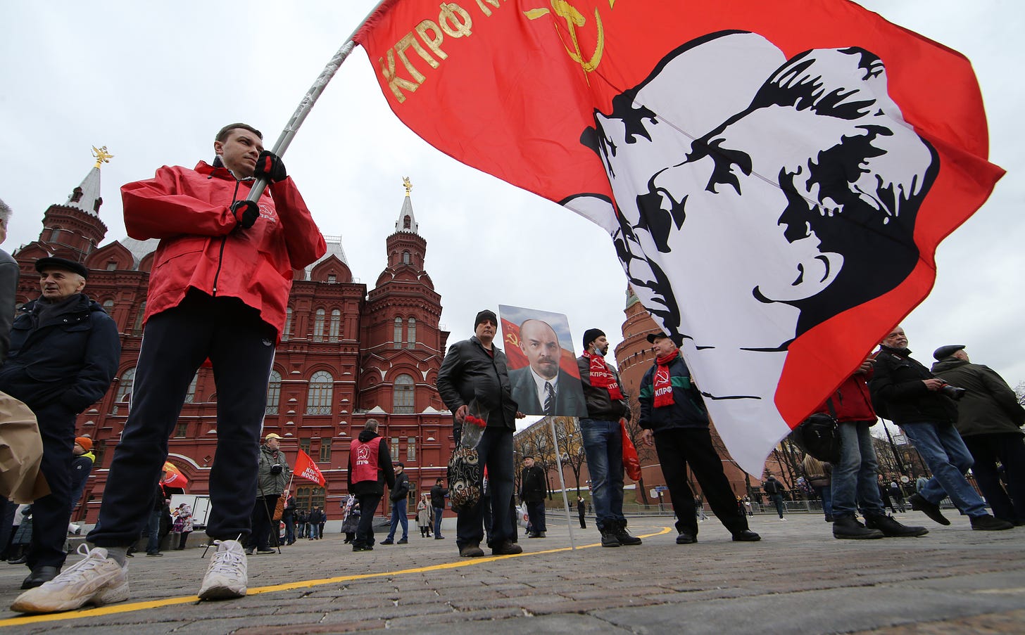 A supporter of Russian Communist Party holds a flag with portrait of Soviet Union leaders Vladimir Lenin and Joseph Stalin on April 22, 2022 in Moscow, Russia. Hundreds communists took part in the rally at Moscow's Red Square near the Kremlin marking the birthday of revolutionary, political theorist and founding head of government of Soviet Russia Vladimir Lenin. (Photo by Konstantin Zavrazhin/Getty Images)