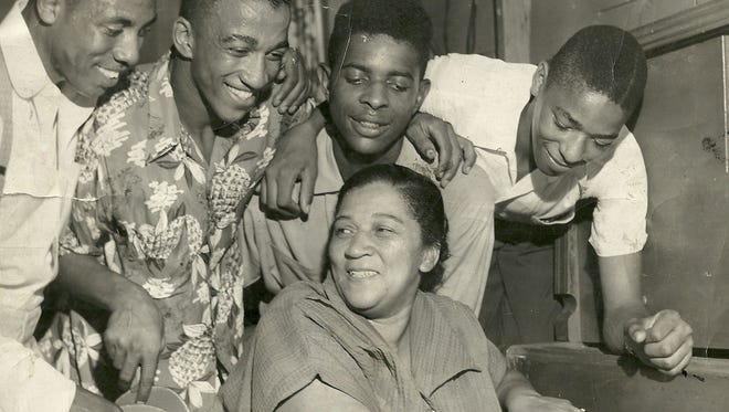 Willie Leola McQuany-Guess, center, is surrounded by her son Wellington and neighborhood youngsters in the Louisville Tigers den, which was a three-car garage converted into a youth clubhouse. She was politically active member of Smoketown. Photo circa 1953.