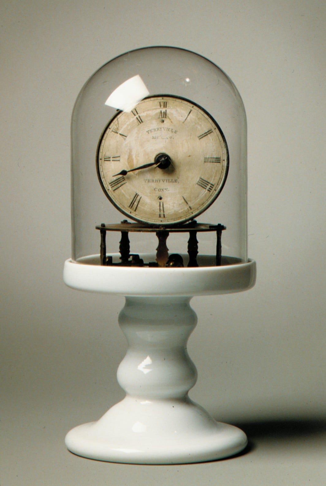 clock on ceramic pedestal with glass cloche