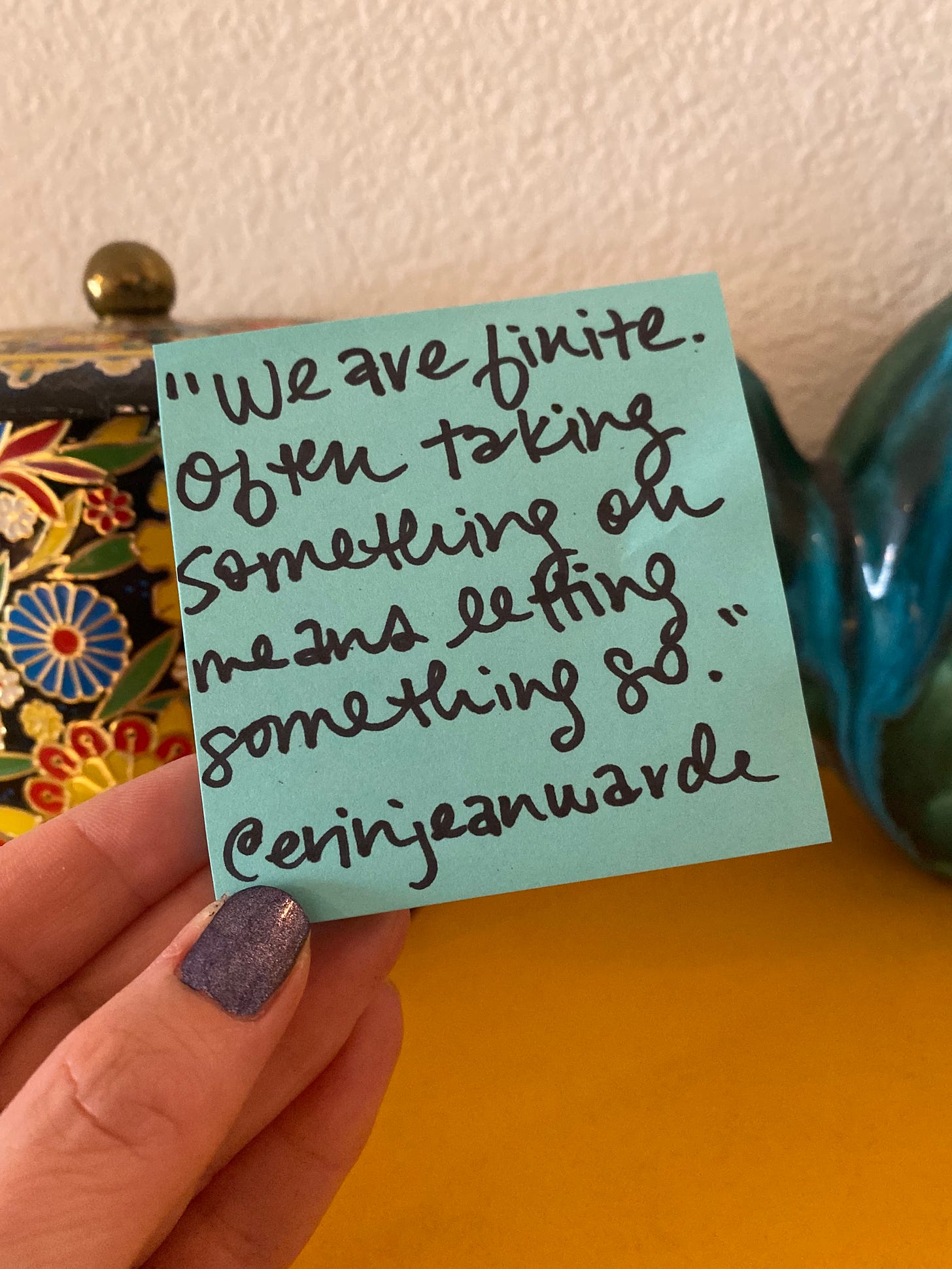 EJW holds a blue post it note with today's quote