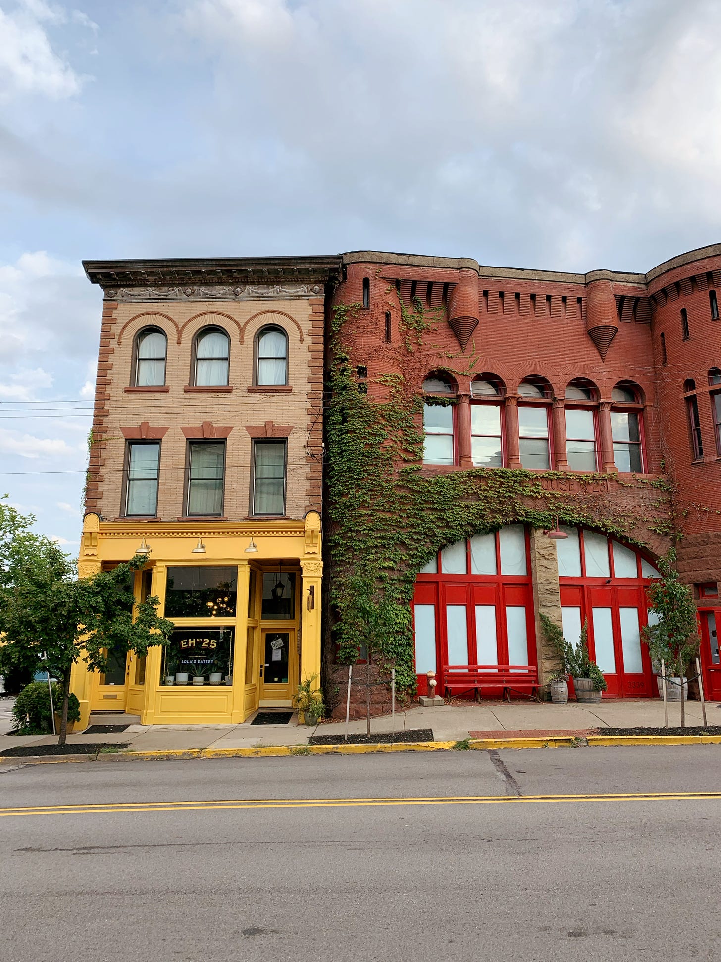 3-story building with painted yellow front and a brick building with ivy all over it