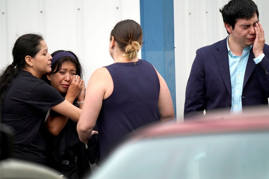 Yesenia Hernandez, second from left, granddaughter to Nicolas Toledo-Zaragoza, who was killed during Monday's Highland Park., Ill., Fourth of July parade, and an unidentified man, right, cry outside the Iglesia Emanuel Church during a private family viewing before the funeral service Friday, July 8, 2022, in Waukegan, Illinois.