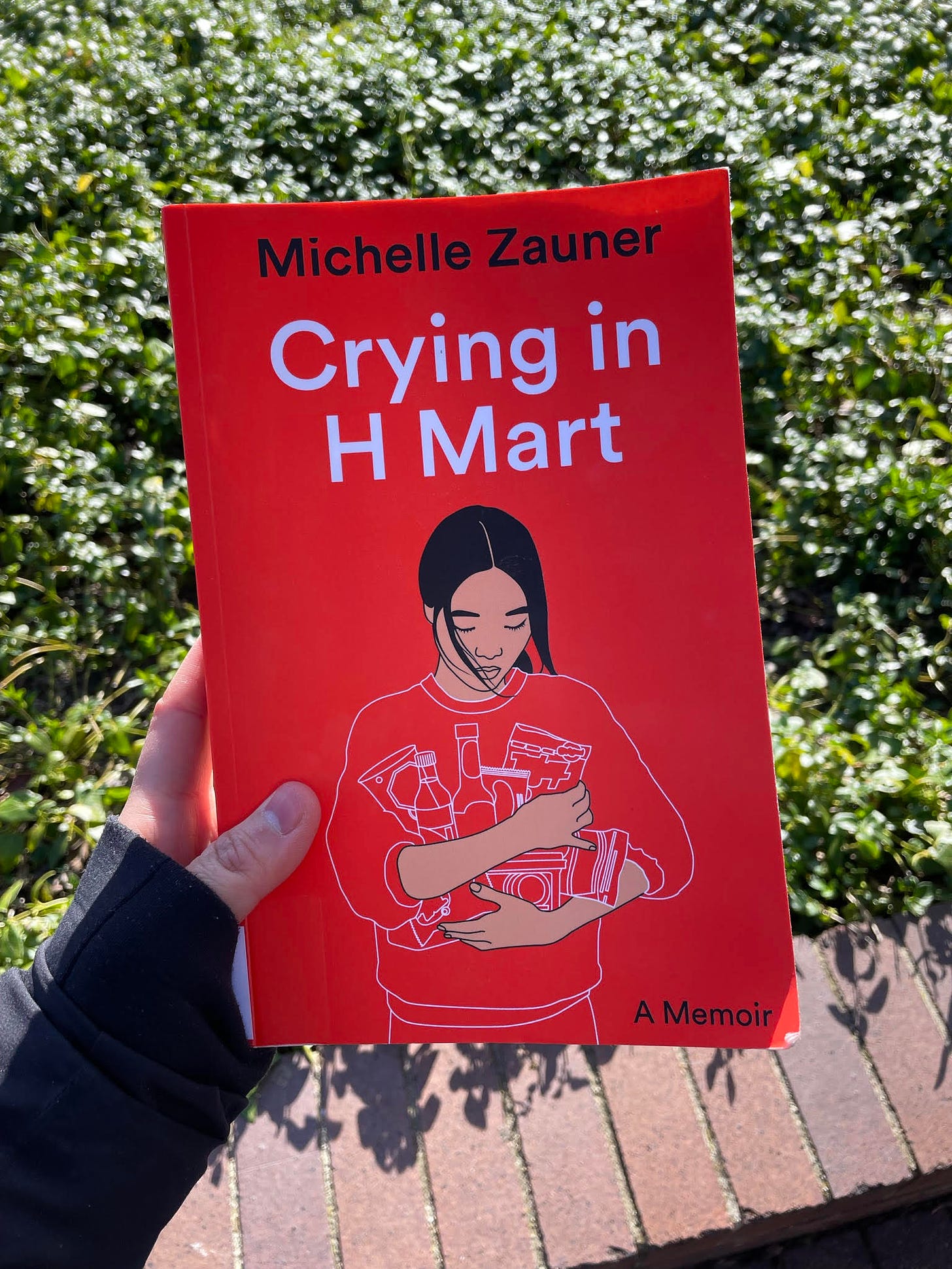 Crying in H Mart book by Michelle Zauner, photographed outside