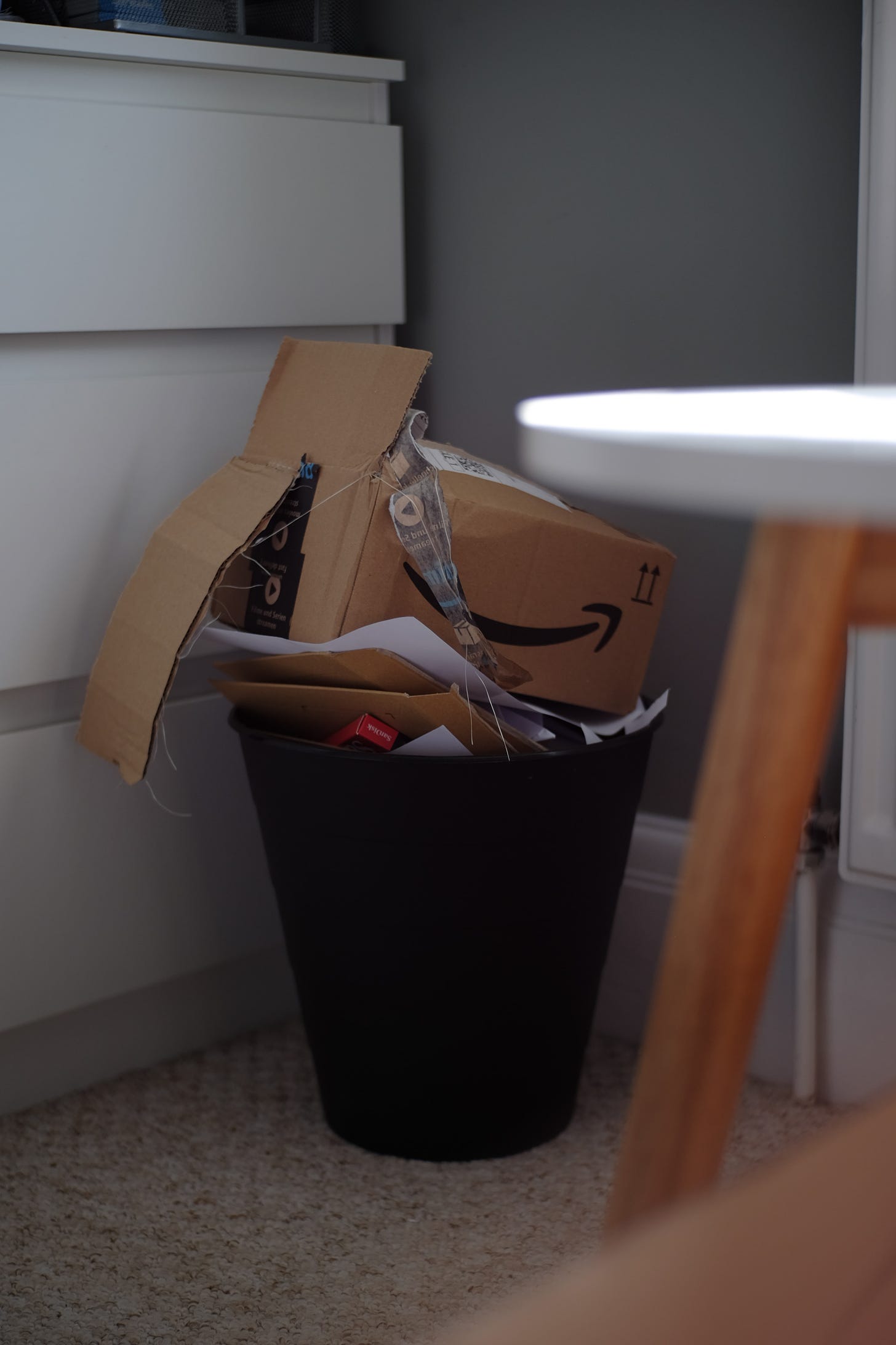 Photo of an Amazon box in the trash. (Sean Robbins / Unsplash)