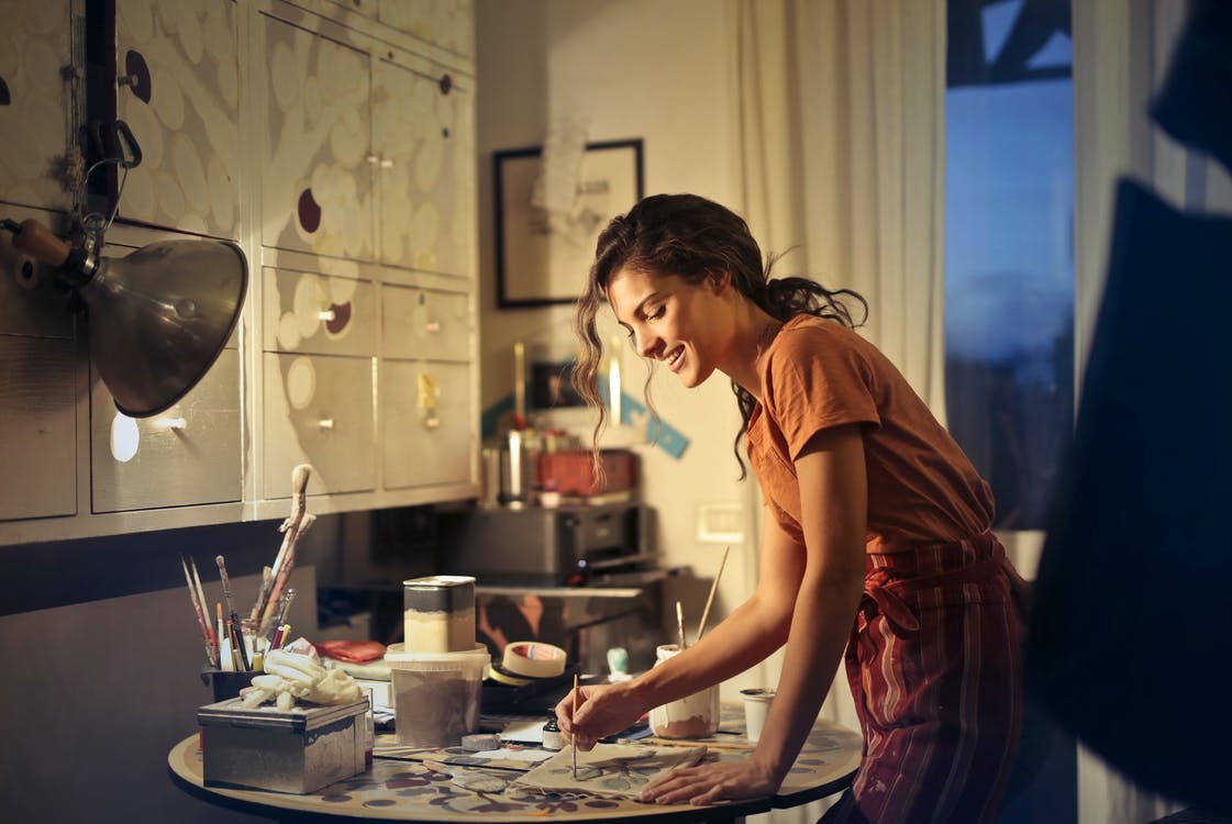 Free Photo of Woman Painting While Smiling and Standing by the Table Stock Photo