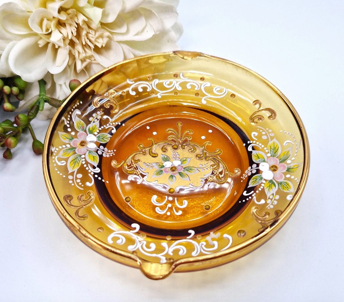 A gorgeous glass dish in translucent orange glass. Stunning hand painted flowers and delicate, ornate embellishments.