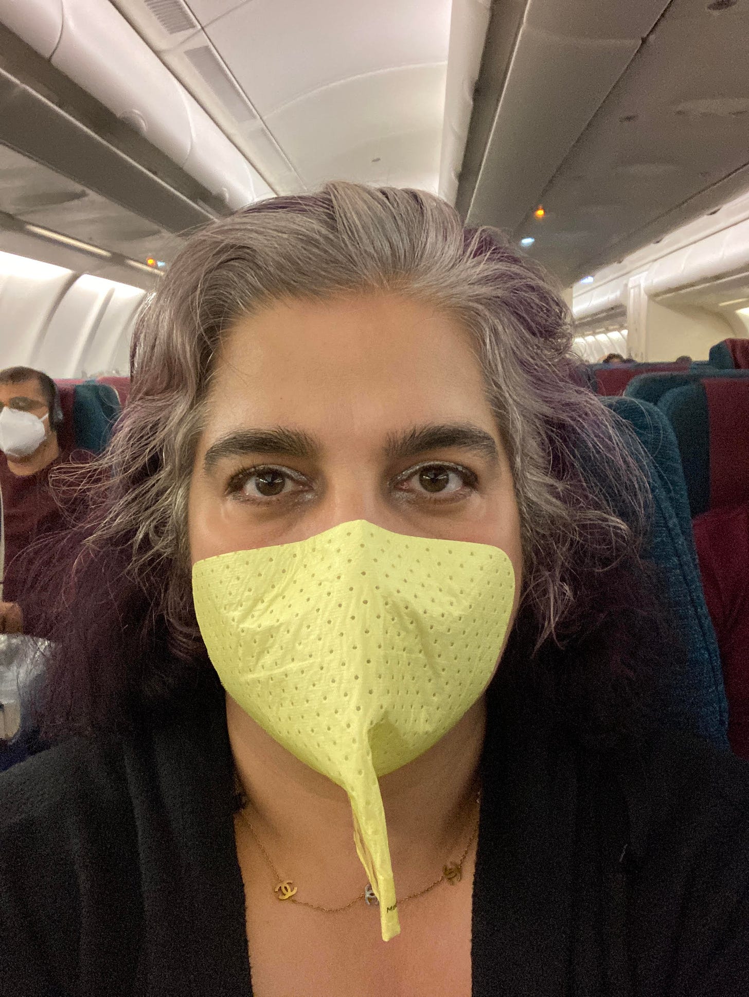 Selfie of Alanna in a stick-on N95 mask. It is yellow.