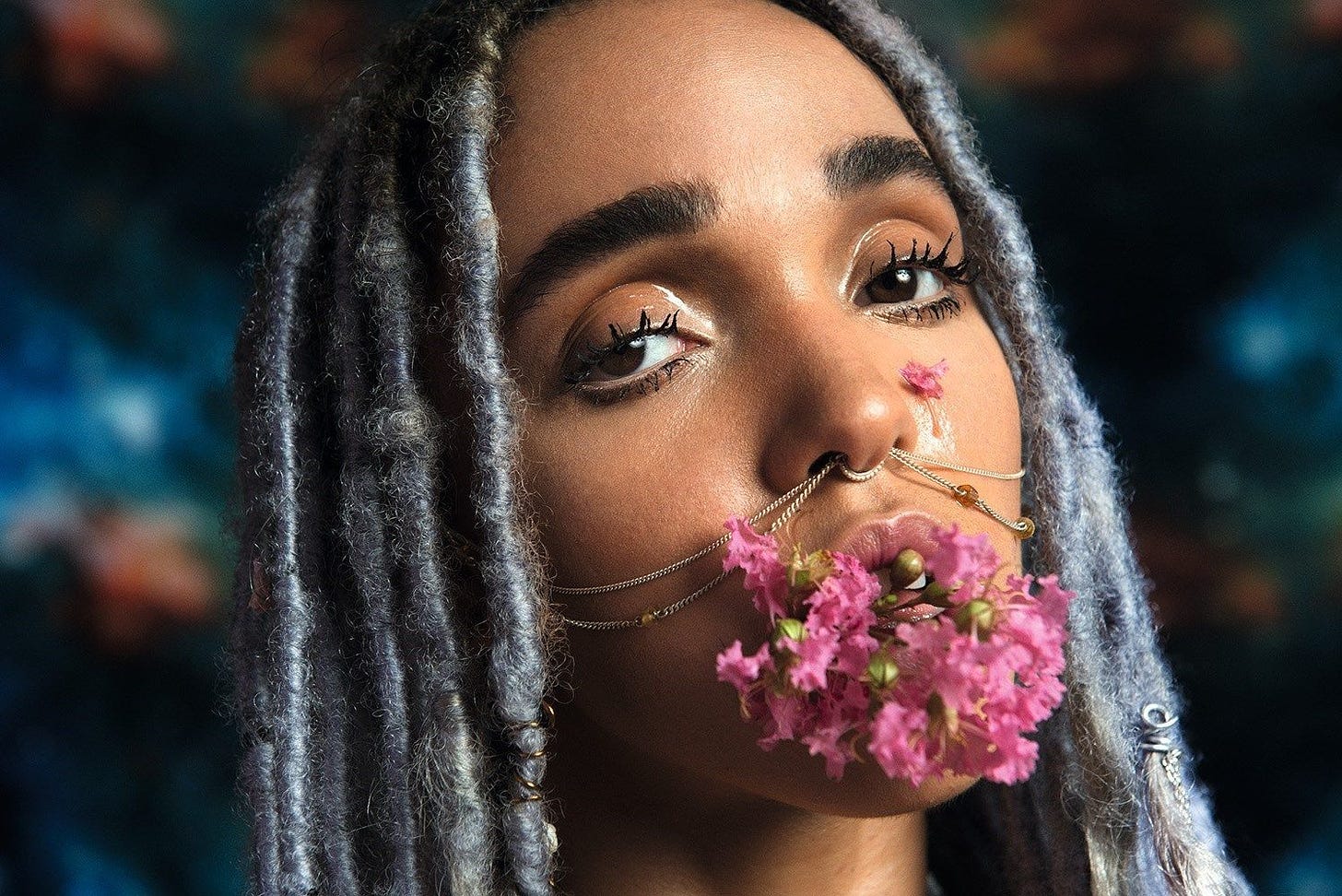 [Alt text: FKA Twigs ritratta con un mazzo di fiori in bocca per Dazed & Confused. Fotografia di Ryan McGingley. Fonte]