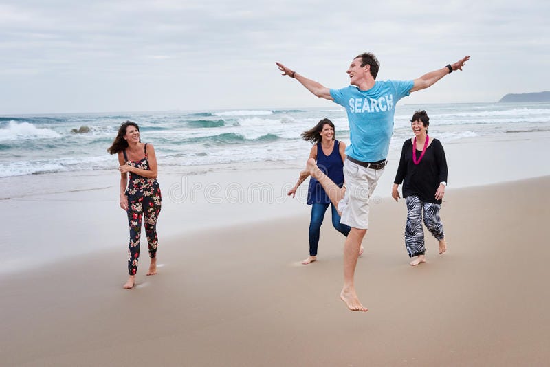 Family being playful together on the beach. Family of four without a father being rediculous together on a beach with overcast weather royalty free stock photos