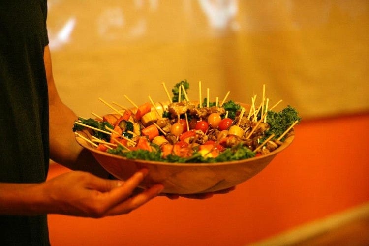 A bowl full of delicious food on skewers