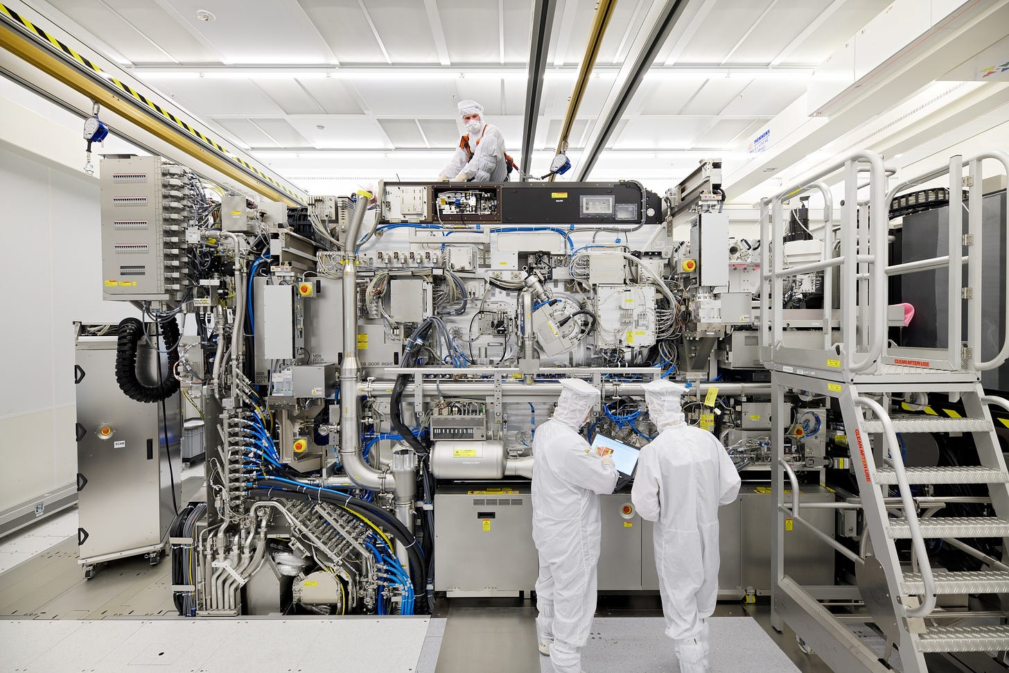 Employees are seen working on the final assembly of ASML's TWINSCAN NXE:3400B semiconductor lithography tool with its panels removed, in Veldhoven, Netherlands, in this picture taken April 4, 2019. Bart van Overbeeke Fotografie/ASML/Handout via REUTERS ATTENTION EDITORS - THIS IMAGE HAS BEEN SUPPLIED BY A THIRD PARTY. MANDATORY CREDIT.