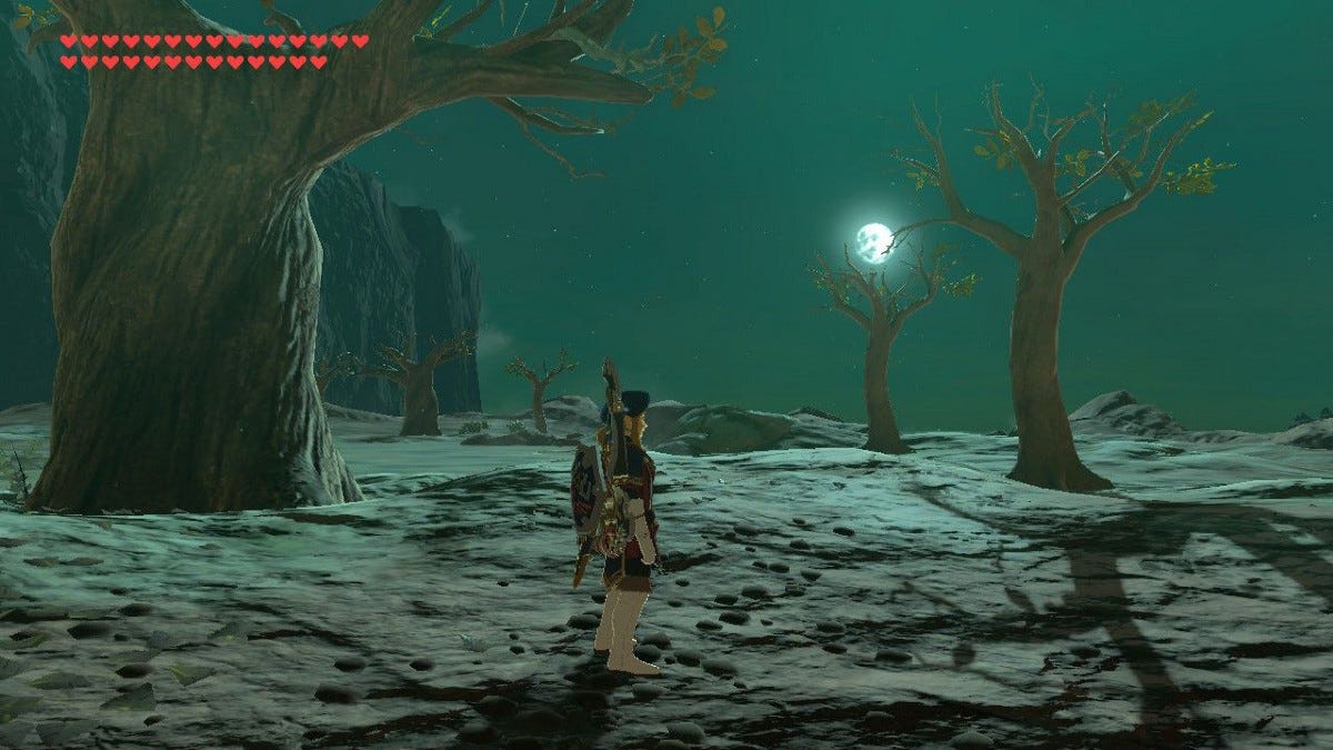 Link standing in a barren volcanic plain dotted with leafless trees at night.