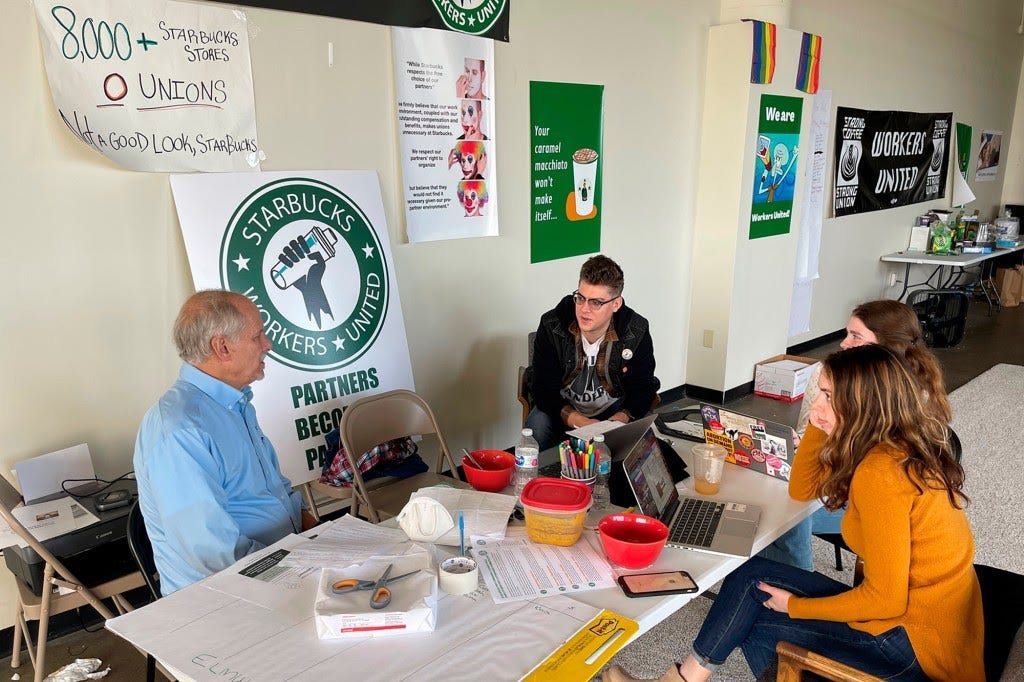 Richard Bensinger, left, who is advising unionization efforts, along with baristas Casey Moore, right, Brian Murray, second from left, and Jaz Brisack, second from right, discuss their efforts to unionize three Buffalo-area stores, inside the movements headquarters on Thursday, Oct. 28, 2021 in Buffalo, N.Y.  