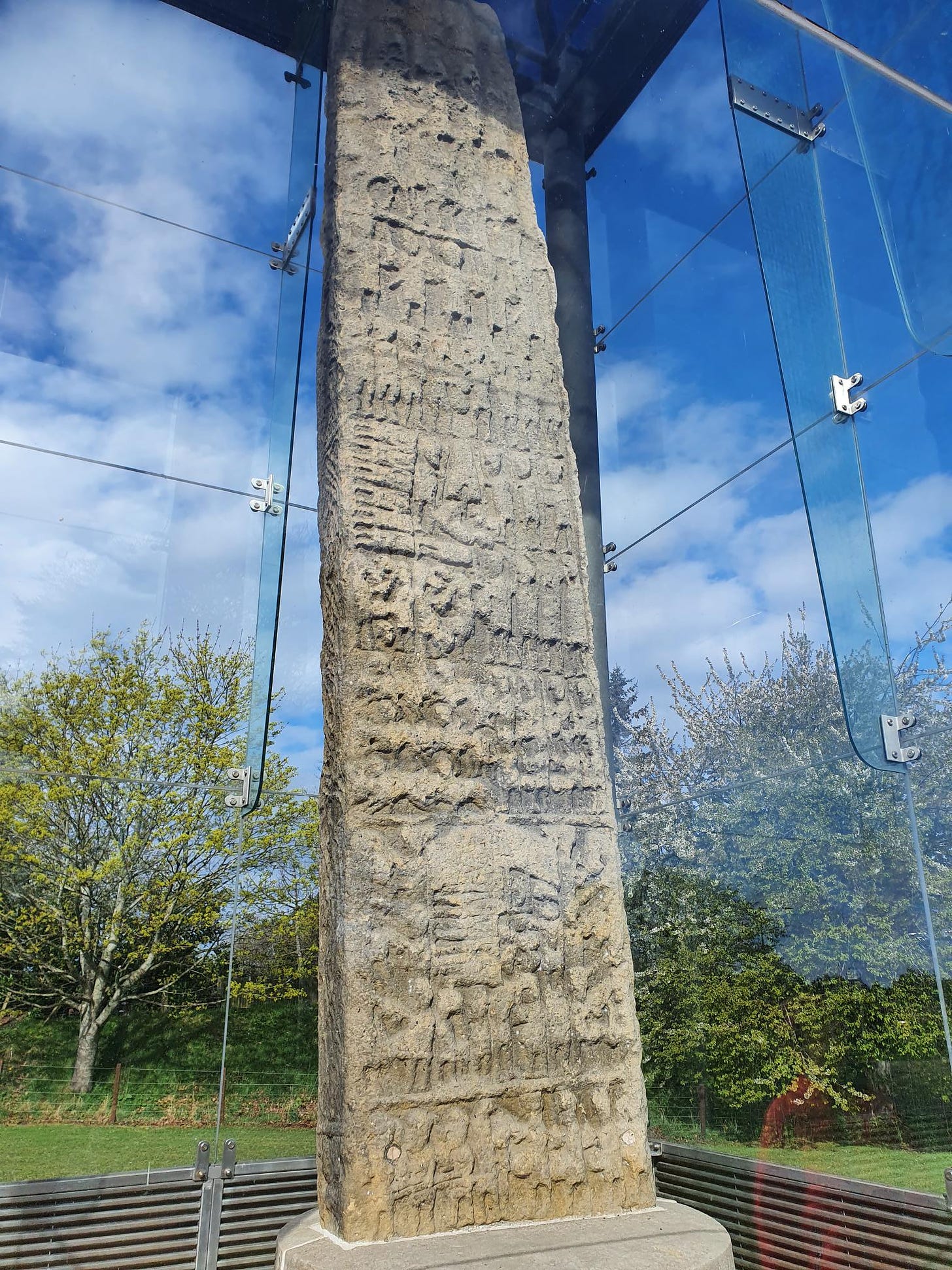 Photo of the east face of Sueno's Stone near Forres, Moray, Scotland - showing its carved battle scenes, now very weathered.