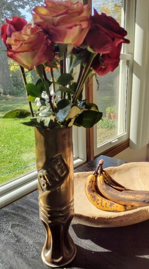 Flowers in vase with bananas in wooden bowl