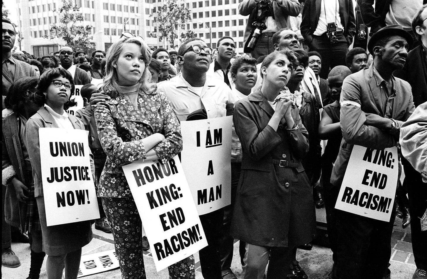 Manifestantes da greve de saneamento de Memphis, em 1968, segurando cartazes contra condições precárias de trabalho e discriminação racial após a morte de dois funcionários. 