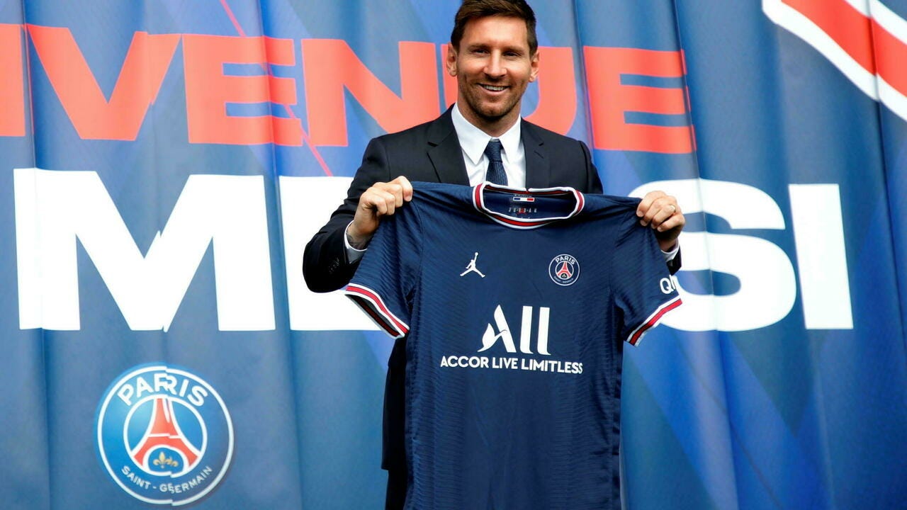 Paris Saint-Germain's Lionel Messi poses with his club's jersey after a press conference at the Parc des Princes in Paris on August 11, 2021.