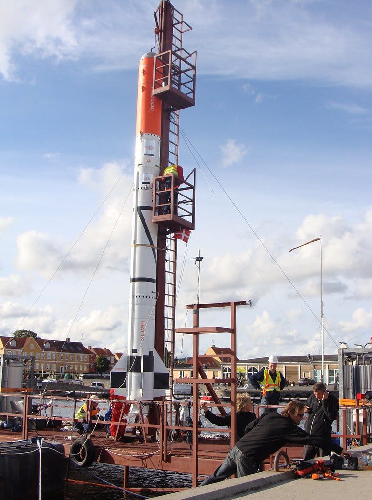 Copenhagen Suborbital's Heat-1X prototype rocket on a launch platform on a clear day.