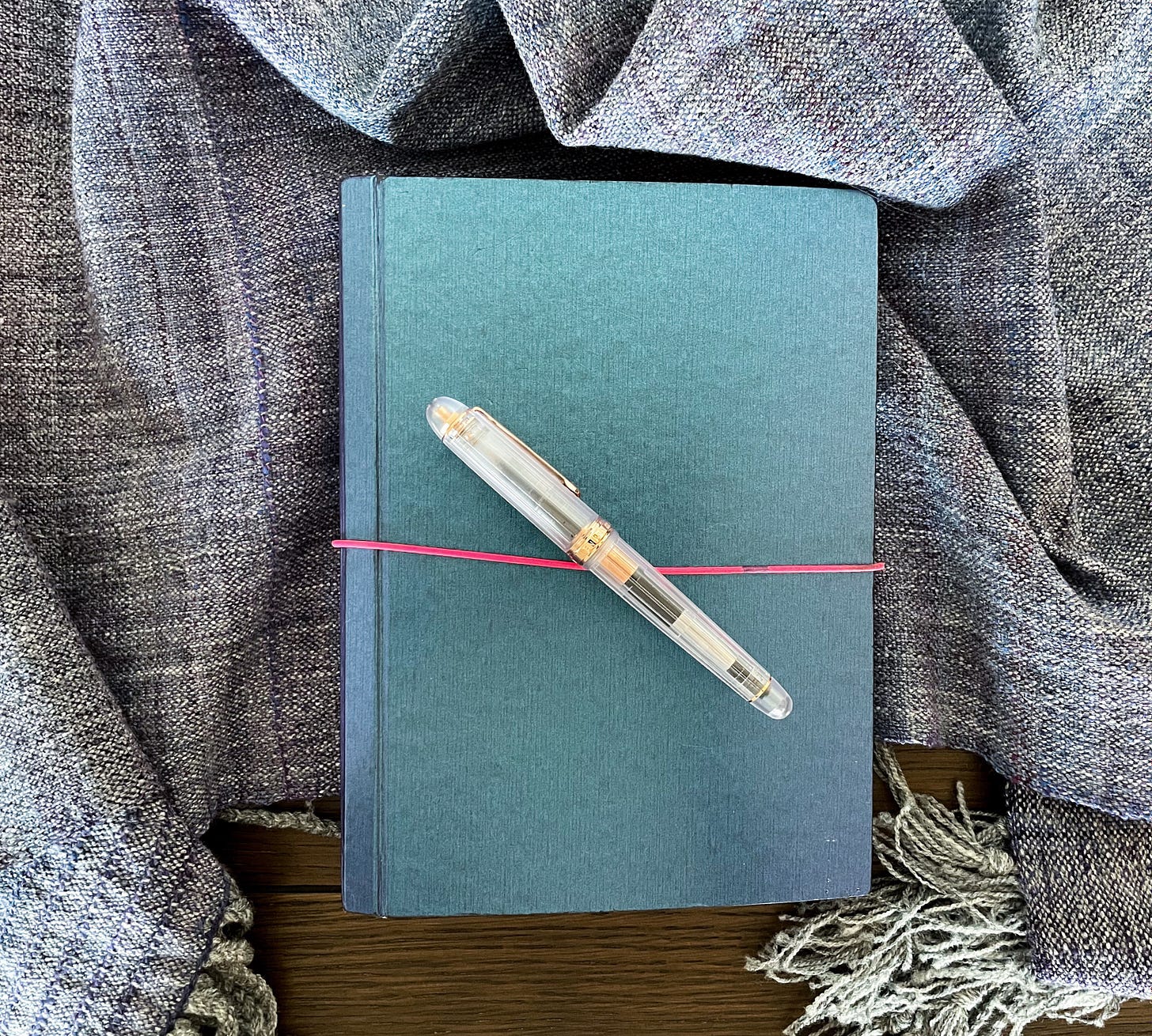 A blue notebook on a woven shawl