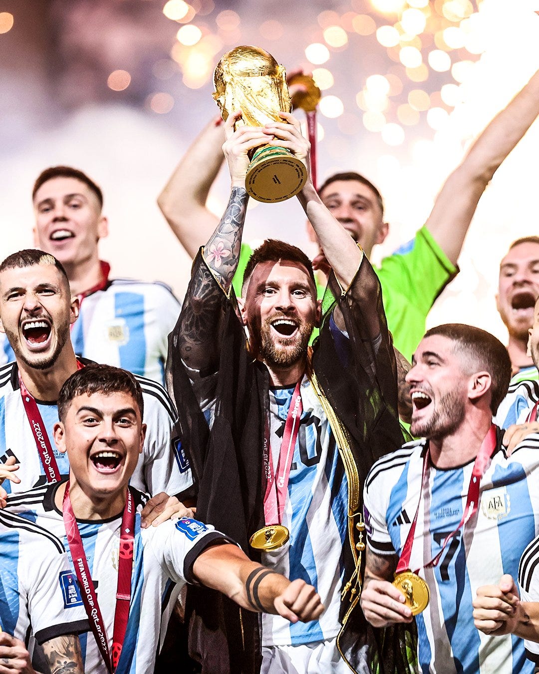 Time da argentina comemora o campeonato mundial, com Messi ao centro levantando a taça.