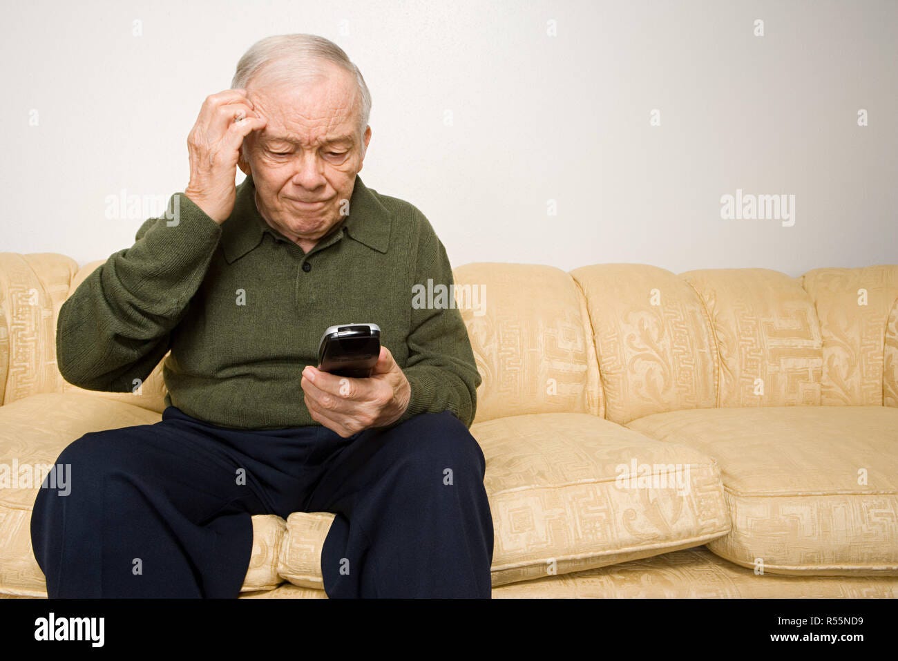 Confused elderly man with remote control Stock Photo - Alamy
