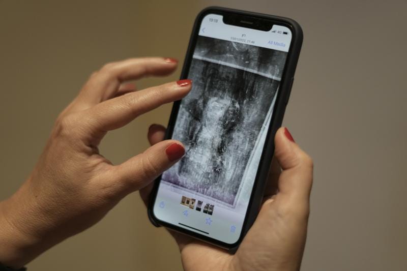 Inna Berkowits, an art historian at the Haifa University's Hecht Museum, holds her mobile phone with an image of an x-ray of Amedeo Modigliani's painting "Nude with a Hat" in Haifa, Israel, June 28, 2022. Curators at the museum using x-ray technology have discovered three previously unknown sketches by the celebrated 20th century artist hiding beneath the surface of the painting. (AP Photo/Ariel Schalit)
