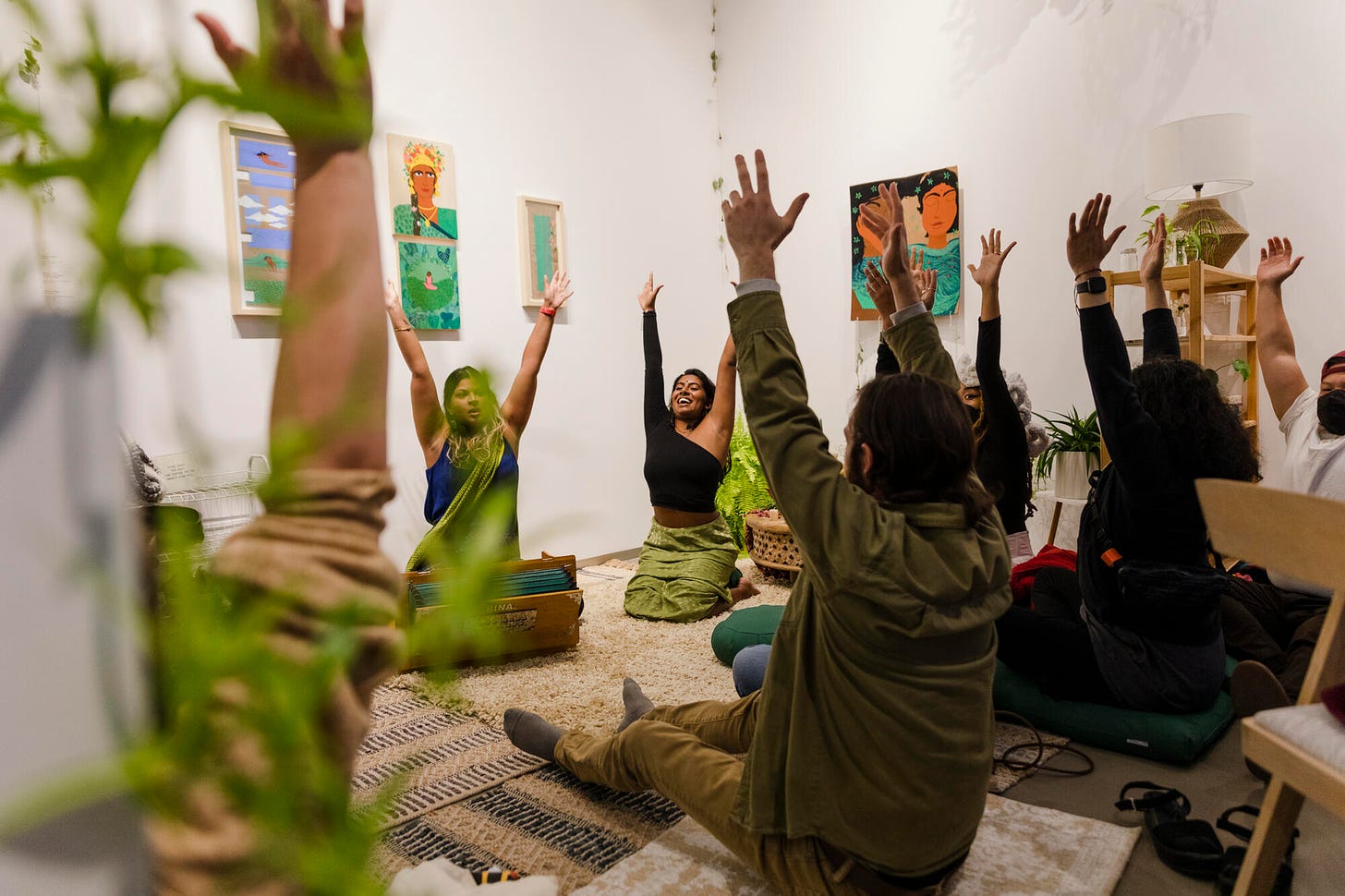 Participants raise their hands through a guided meditation at the Crossings Gallery.