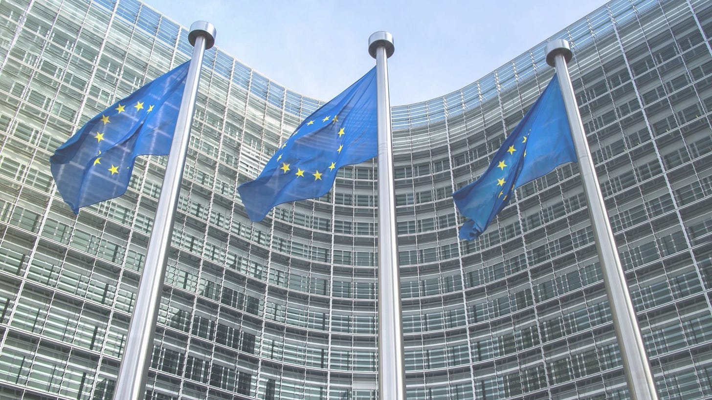 Three flagpoles with Europe Flags in front of a building