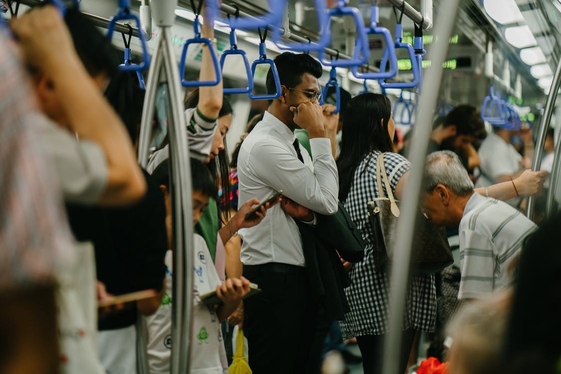 Man in Train Standing looking fed up