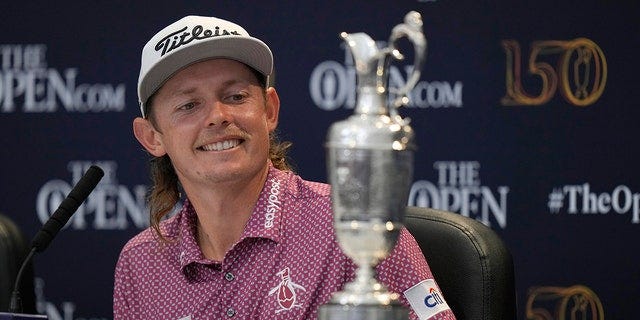 Cameron Smith, of Australia, looks at the Claret Jug trophy during a press conference after winning the British Open golf championship on the Old Course at St. Andrews, Scotland, Sunday July 17, 2022. 