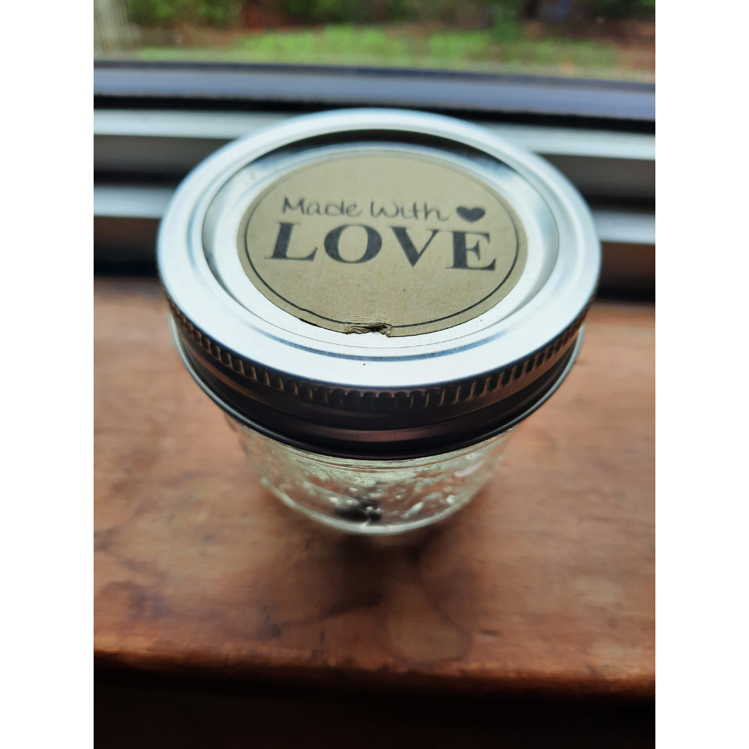 photo of a engorged tick in a small glass jar that says Made with Love on the lid.