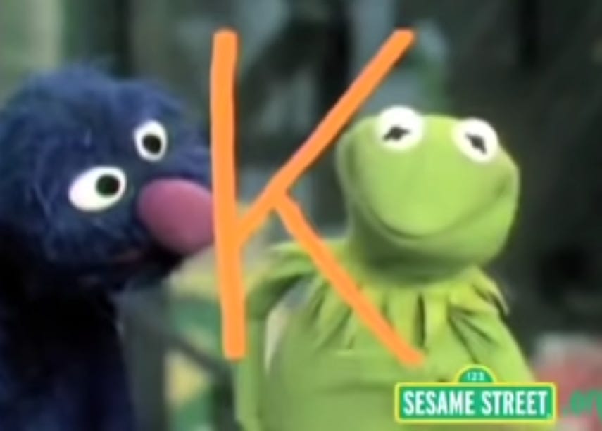 Grover and Kermit admire the letter K