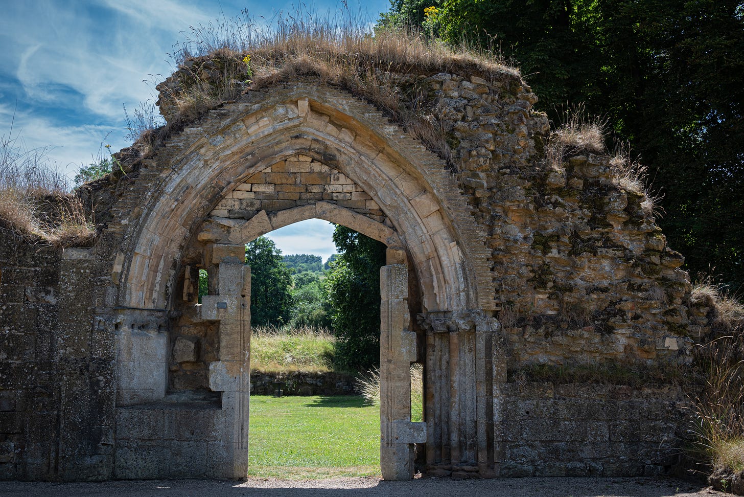 A doorway in the ancient Hailles Abbey in England. Only fragments of the structure remain including this one archway and door looking out at the Cotswold landscape