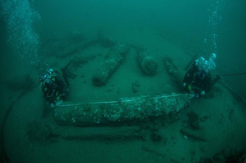 In this undated photo provided by Norfolk Historic Shipwrecks, Julian And Lincoln Barnwell measure the cannon found on the HMS Gloucester in 2007. Excavators and historians are telling the world about the wreck of a royal warship that sank in 1682 while carrying the future king James Stuart. The HMS Gloucester ran aground while navigating sandbanks off the town of Great Yarmouth on the eastern English coast. The wreck of the Gloucester was found in 2007 by brothers Julian and Lincoln Barnwell and others after a four-year search. (Norfolk Historic Shipwrecks via AP)