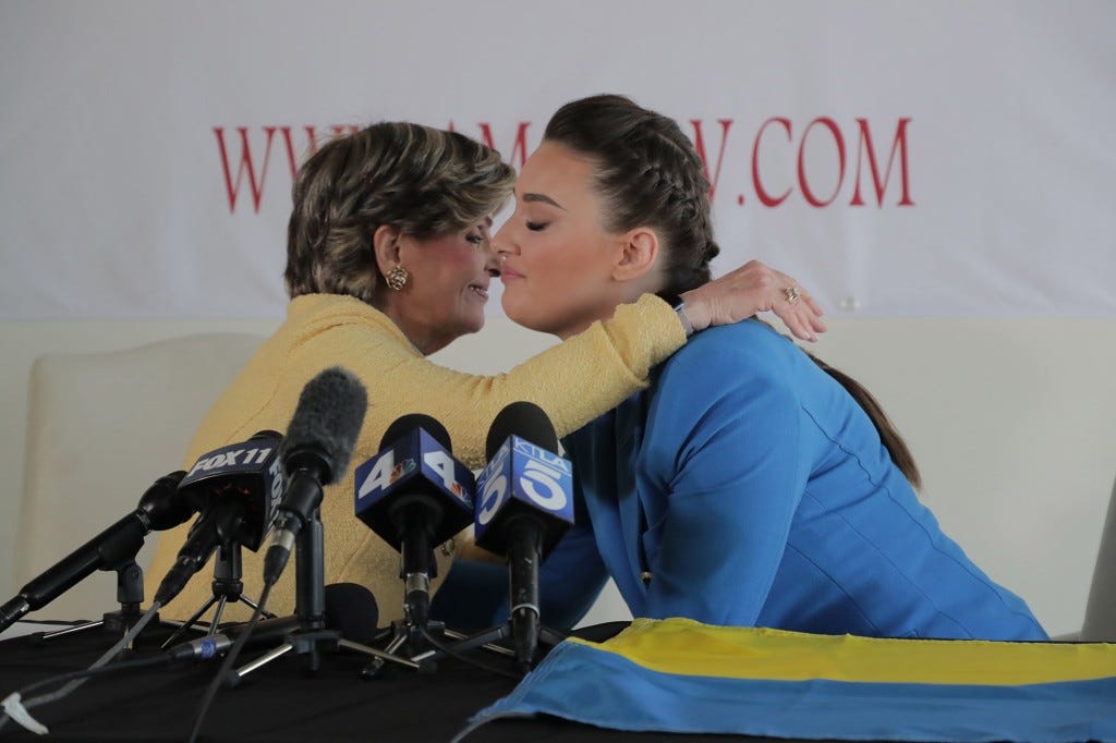 Miss Ukraine 2018 Veronika Didusenko and women's rights attorney Gloria Allred hold Ukrainian national flag during a news conference organised to speak about fleeing the war in Ukraine with her son.