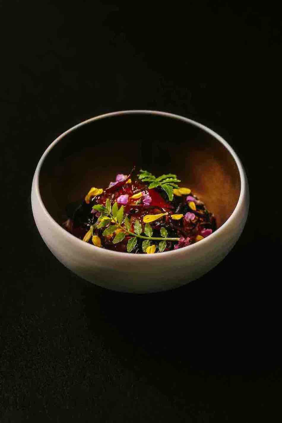 Abalone, abalone dashi broken gel, hanaho flowers, kinome, and hijiki seaweed