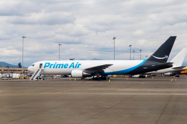 米国ワシントン州シアトル-2018年5月26日：クラウドの日に空港に駐車したAmazonの貨物配達船団の1つ