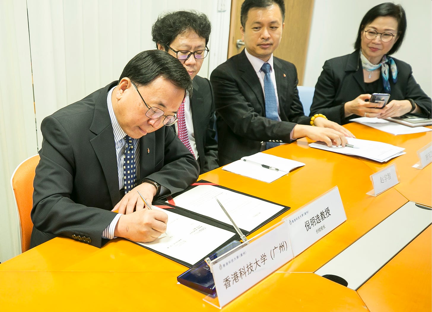 HKUST(GZ)’s President Prof. Ni (first from the left) signs the agreement in Hong Kong