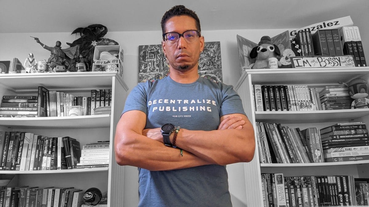 Me, arms crossed, in a "Decentralize Publishing" shirt from Hub City Press
