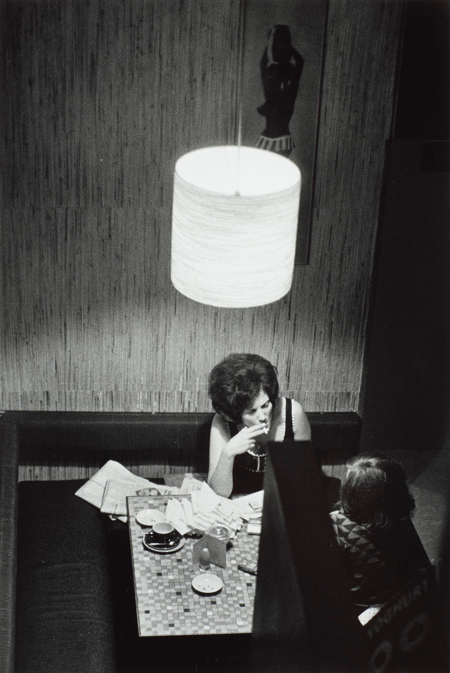 An overheard photo of two women sitting at a table with a pile of letters