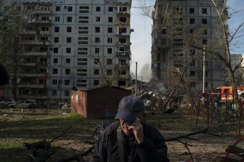 Mucola Markovich, 76, wipes a tear as he stands next to a residential building that was heavily damaged after a Russian attack at a residential area in Zaporizhzhia, Ukraine, Sunday, Oct. 9, 2022. (AP Photo/Leo Correa)
