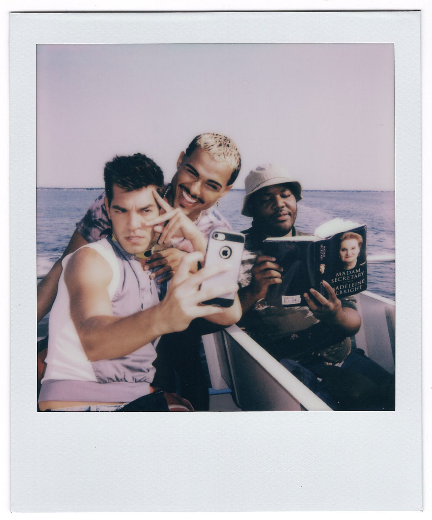 Pictures are three young men/friends on the ferry to Fire Island, two are taking a selfie and one is reading the memoir of Madeleine Albright, with the caption: Finding fun and love amidst social rules, restraints, class anxiety, and discrimination - it’s all there in ‘Fire Island’ and in Jane Austen. Photo: A scene from ‘Fire Island’ | Photo courtesy of Searchlight Pictures Pictures are three young men/friends on the ferry to Fire Island, two are taking a selfie and one is reading the memoir of Madeleine Albright, with the caption: Finding fun and love amidst social rules, restraints, class anxiety, and discrimination - it’s all there in ‘Fire Island’ and in Jane Austen. Photo: A scene from ‘Fire Island’ | Photo courtesy of Searchlight Pictures