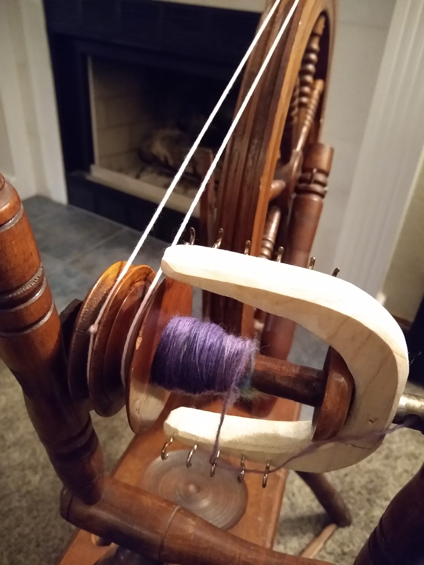 Spinning wheel with purple yarn on the bobbin