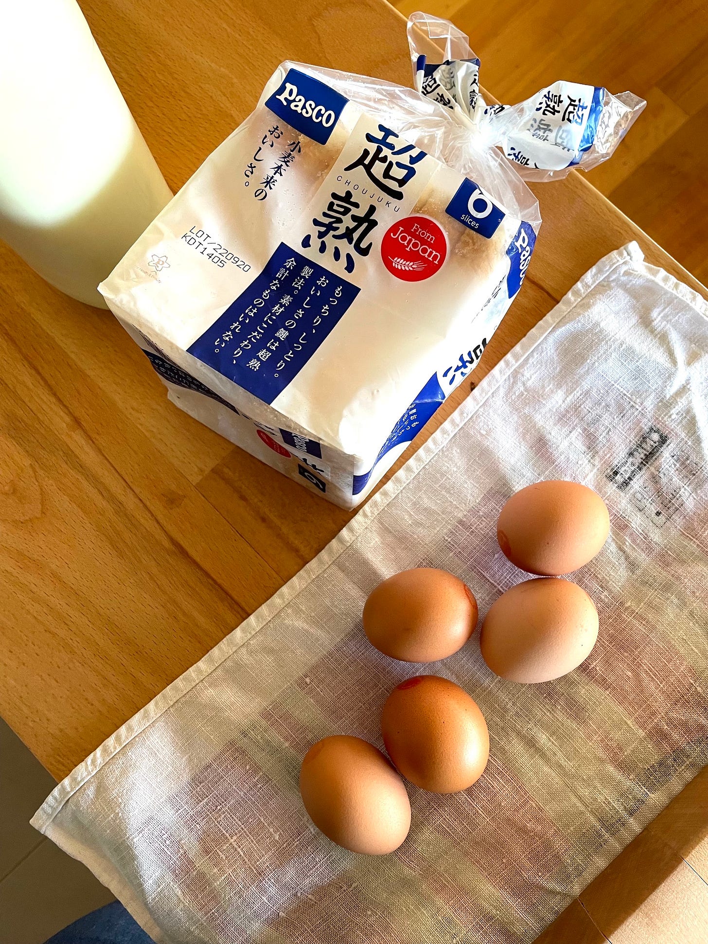 Packet of milk bread with a bottle of milk and five eggs