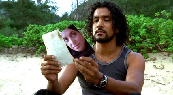 Sayid Jarrah (Naveen Andrews) sits on the beach and examines a letter and the back of a photograph of a woman whose face can be clearly viewed.