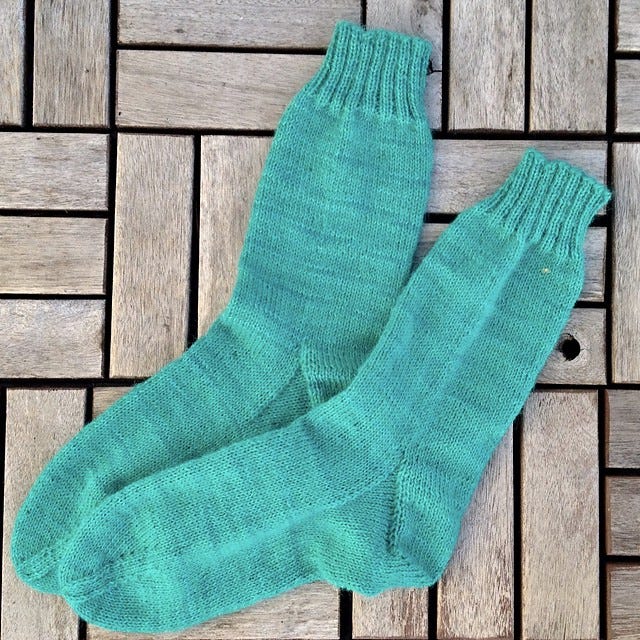 turquoise socks knitted in plain stocking stitch